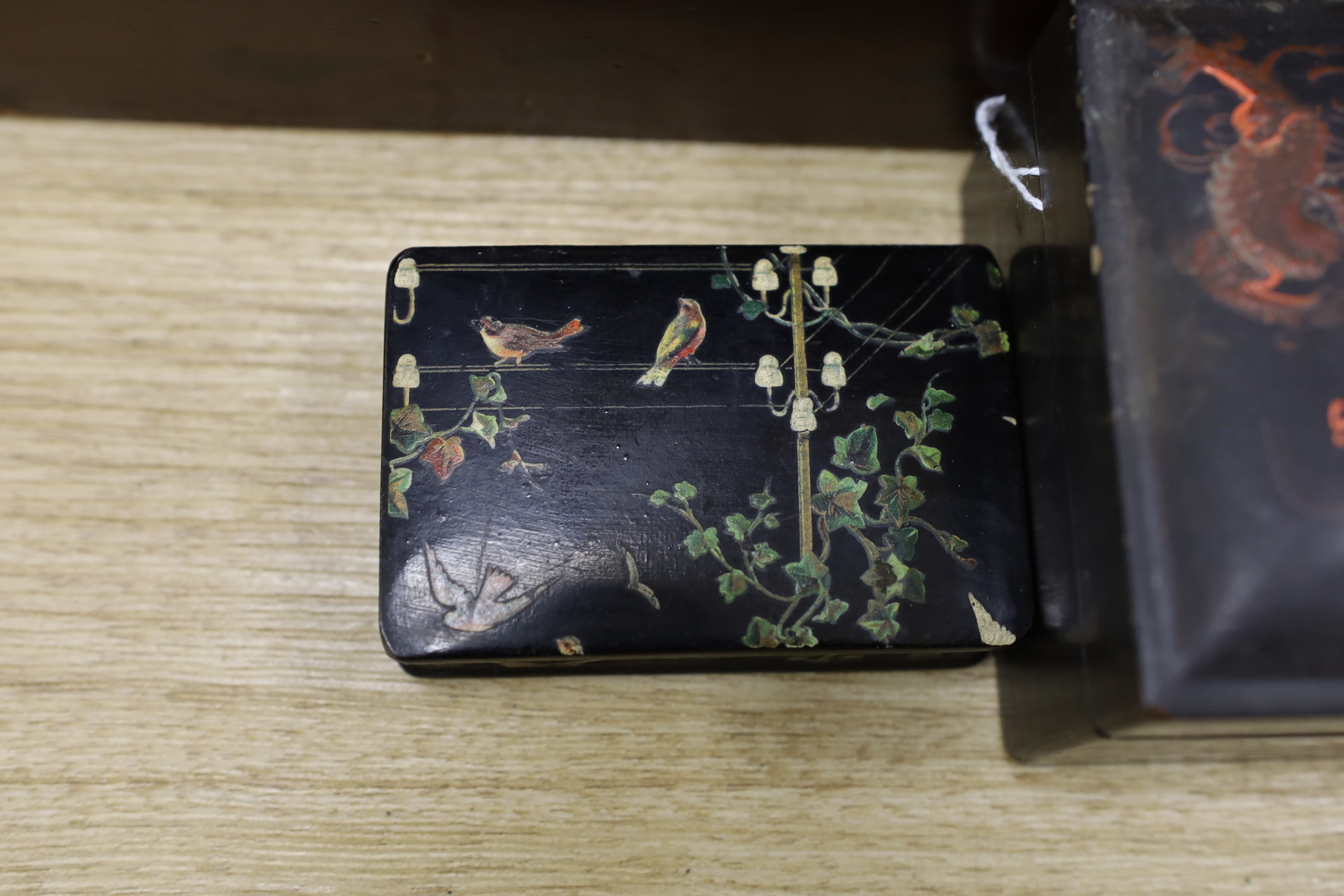 A Japanese lacquer writing box and three black lacquer or papier mache boxes